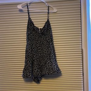 black romper with white floral detail. adjustable straps